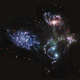 A galactic quintet as seen in three mid-infrared filters. In mid-infrared, a purple tint dominates the focused galaxies, while background galaxies are a collection of reds, yellows and blues.